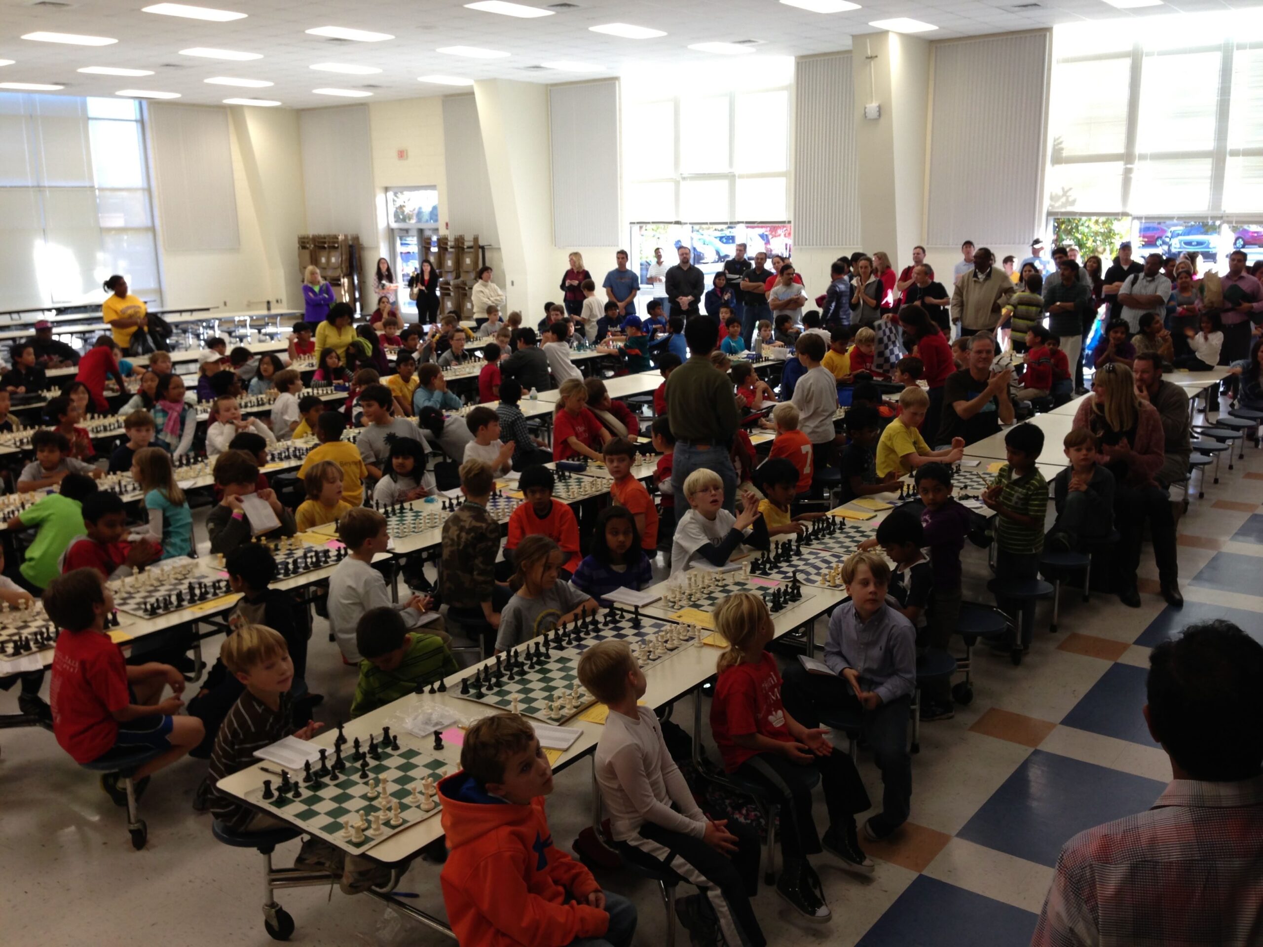 A large scholastic chess room filled with students.