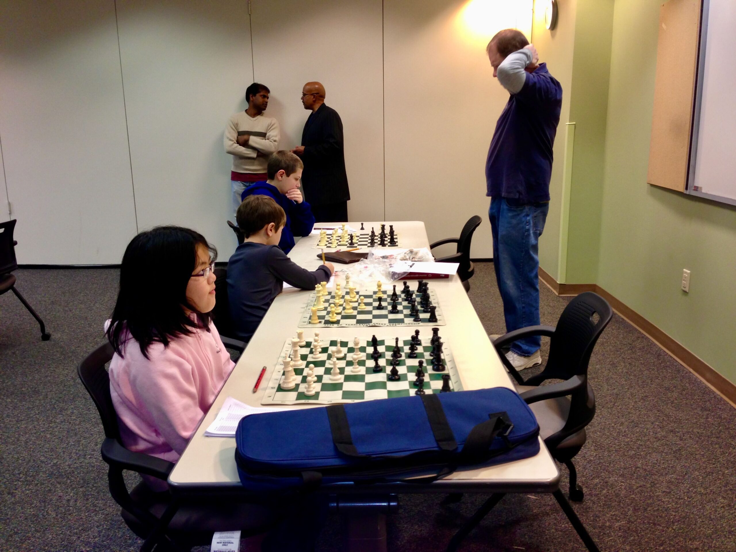 Bernard teaching a small group of students at boards.